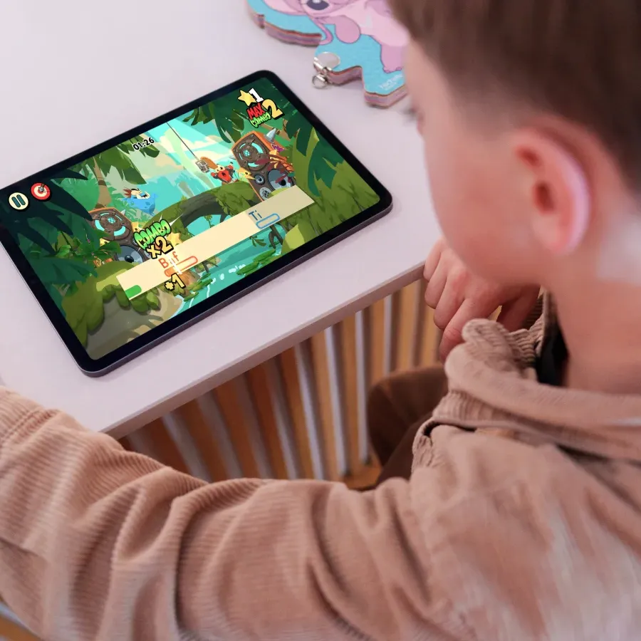 A child playing a Poppins Learning reading game on a tablet at home